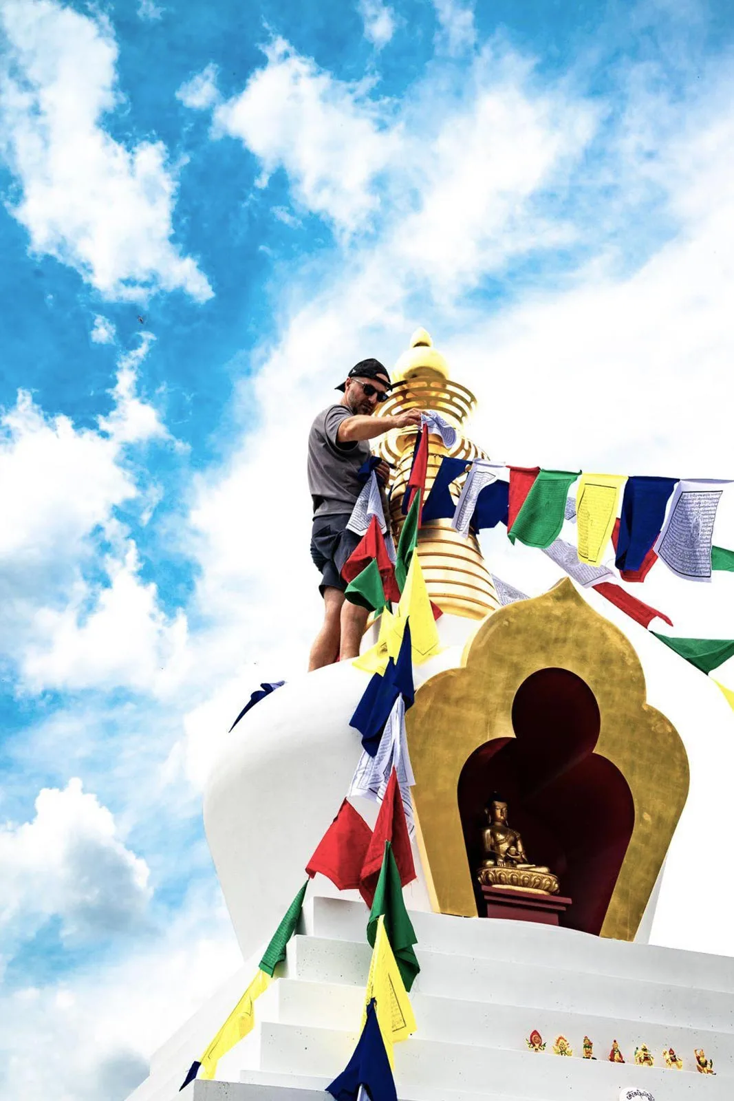Daily routine for freelancers - Leo Grzyb hanging Buddhist prayer flags at the Enlightenment Stupa in KKPL, Czech Republic.