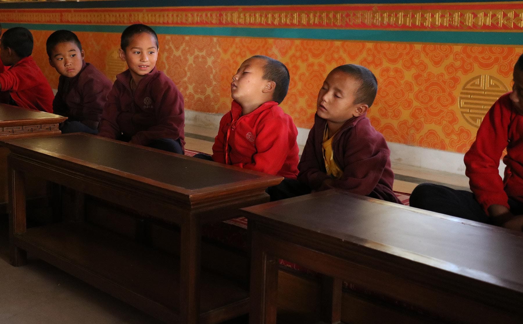 How to stay motivated - Young monks try to maintain their concentration during the morning meditation in a Buddhist monastery.